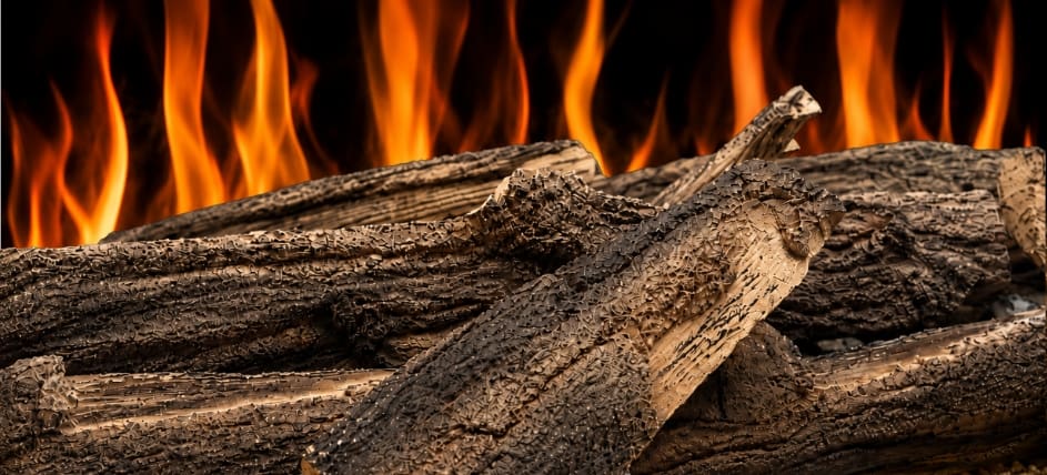 Woodland electric fireplace log set close-up with realistic bark texture, glowing ember detail and bright flame effect.